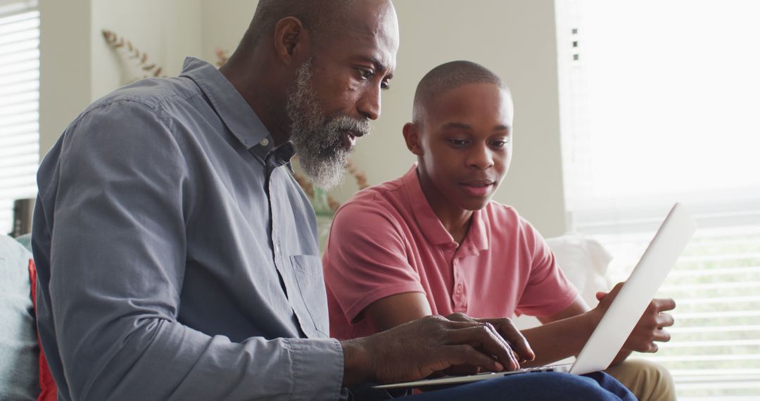 Image of happy african american father and son using laptop together - Free Images, Stock Photos and Pictures on Pikwizard.com