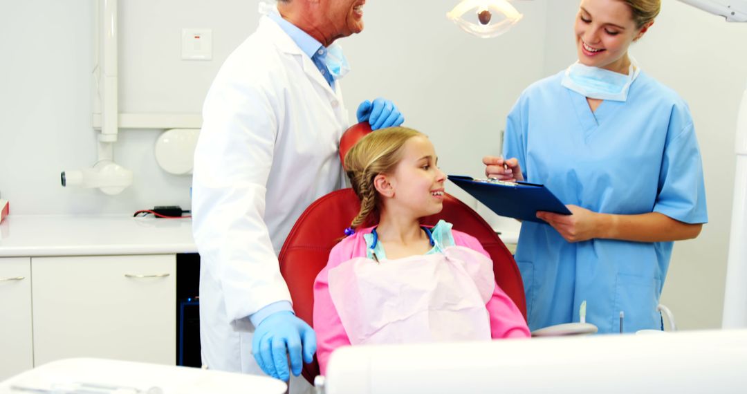 Young Girl Relaxing During Dental Check-up with Dentist and Assistant - Free Images, Stock Photos and Pictures on Pikwizard.com