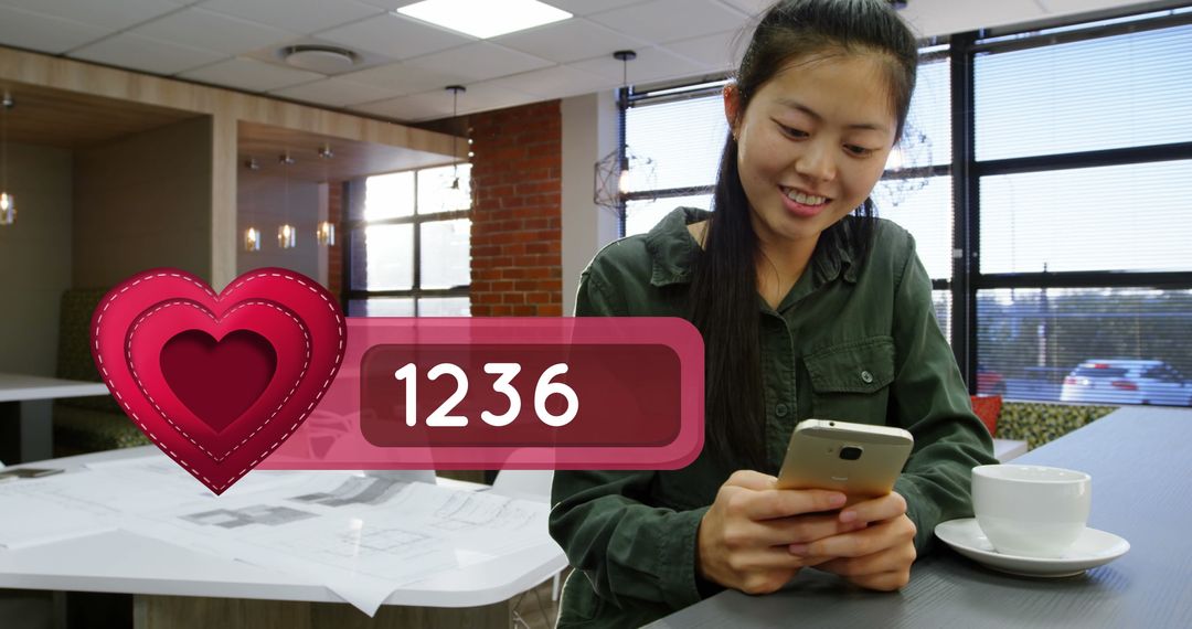 Smiling Asian Woman Engaging on Smartphone in Cafe