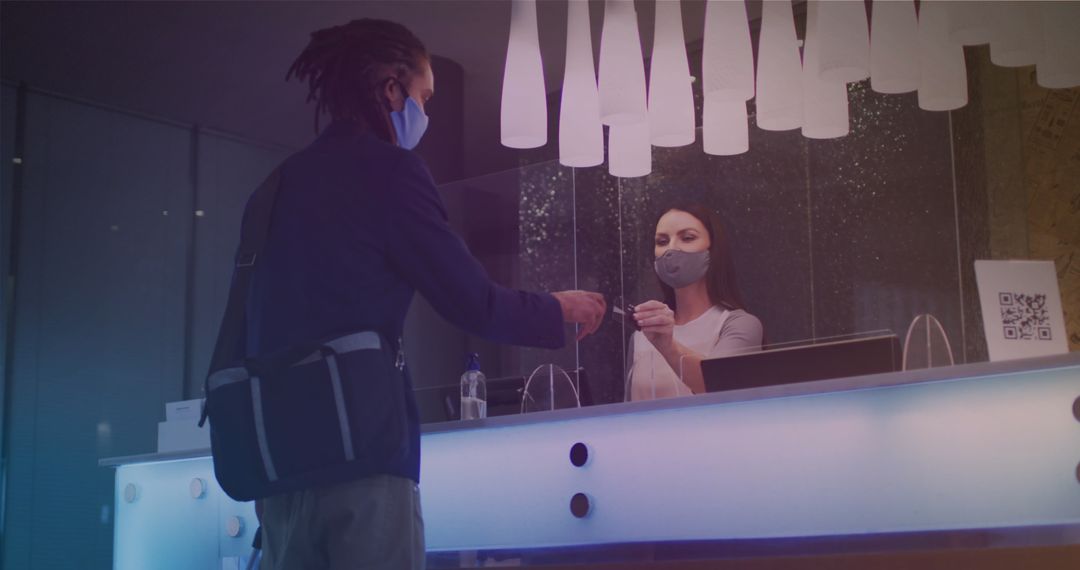 Man in Mask Making Contactless Payment at Hotel Reception