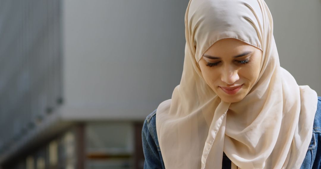 Smiling Woman in Hijab Using Smartphone in Urban Environment
