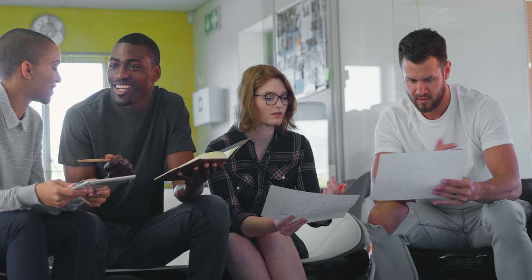 Diverse Business Team Collaborating Over Documents in Modern Office