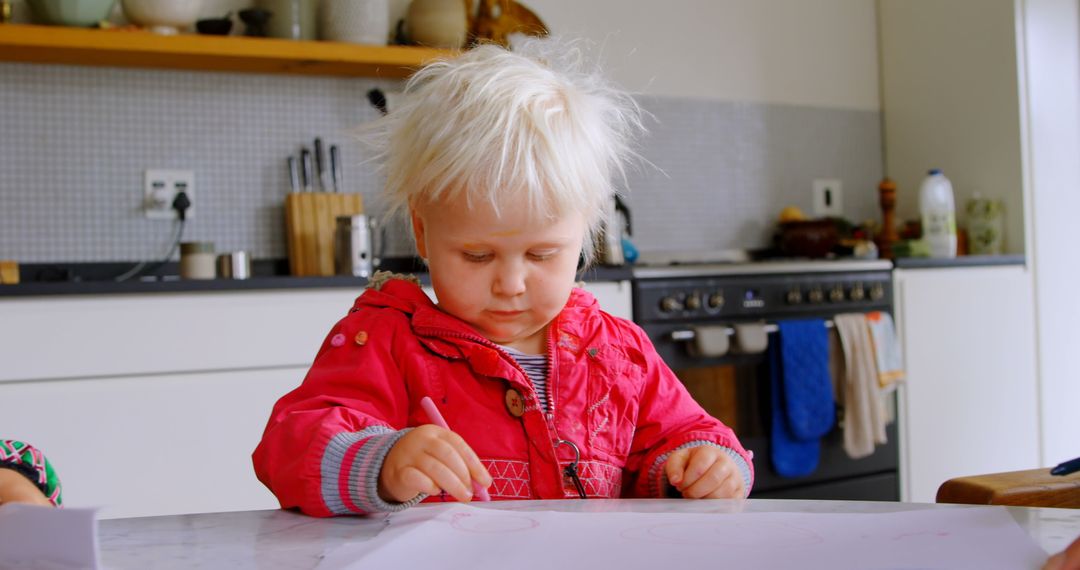 Blond Toddler Engaged in Drawing at Modern Kitchen Table