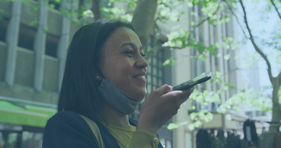 Woman Using Smartphone for Voice Message on City Sidewalk