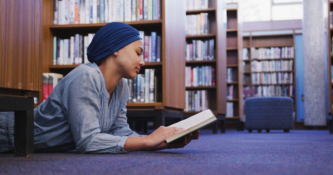 Young Woman Reading Book on Library Floor - Free Images, Stock Photos and Pictures on Pikwizard.com