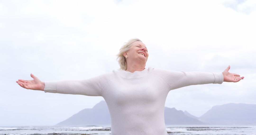 Elderly Woman Enjoying Freedom at Seaside - Free Images, Stock Photos and Pictures on Pikwizard.com