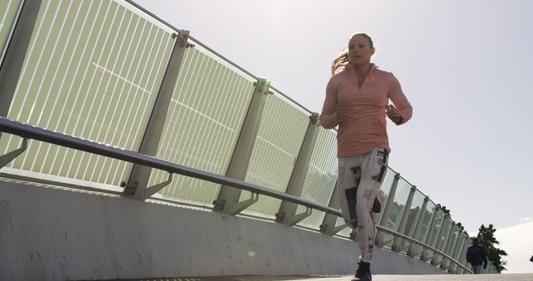 Woman Jogging on Modern Bridge on Sunny Day - Free Images, Stock Photos and Pictures on Pikwizard.com