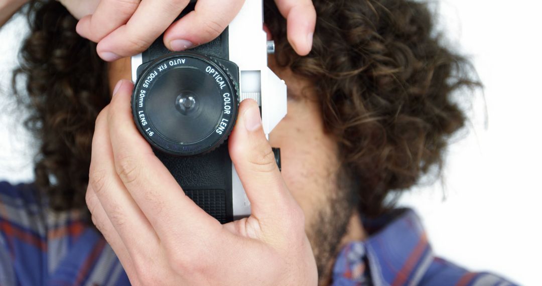 Man with Curly Hair Taking Photograph with Vintage Camera Concept
