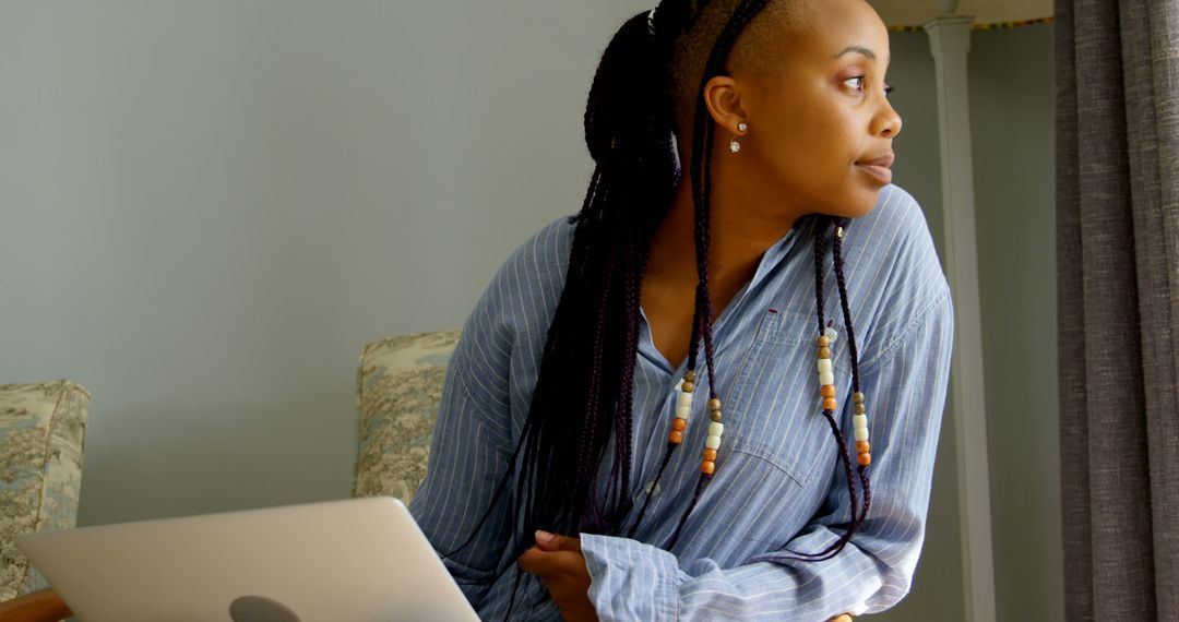 Side view of young black woman using digital tablet and sitting on the couch in comfortable home - Free Images, Stock Photos and Pictures on Pikwizard.com