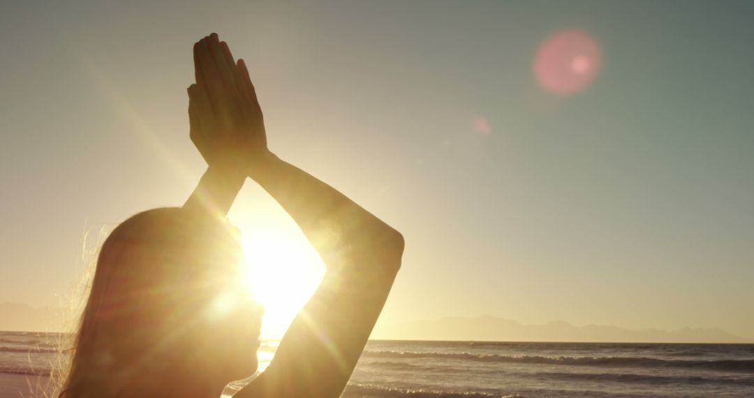 Woman Meditating at Sunrise on Beach Silhouetted by Sunlight - Free Images, Stock Photos and Pictures on Pikwizard.com