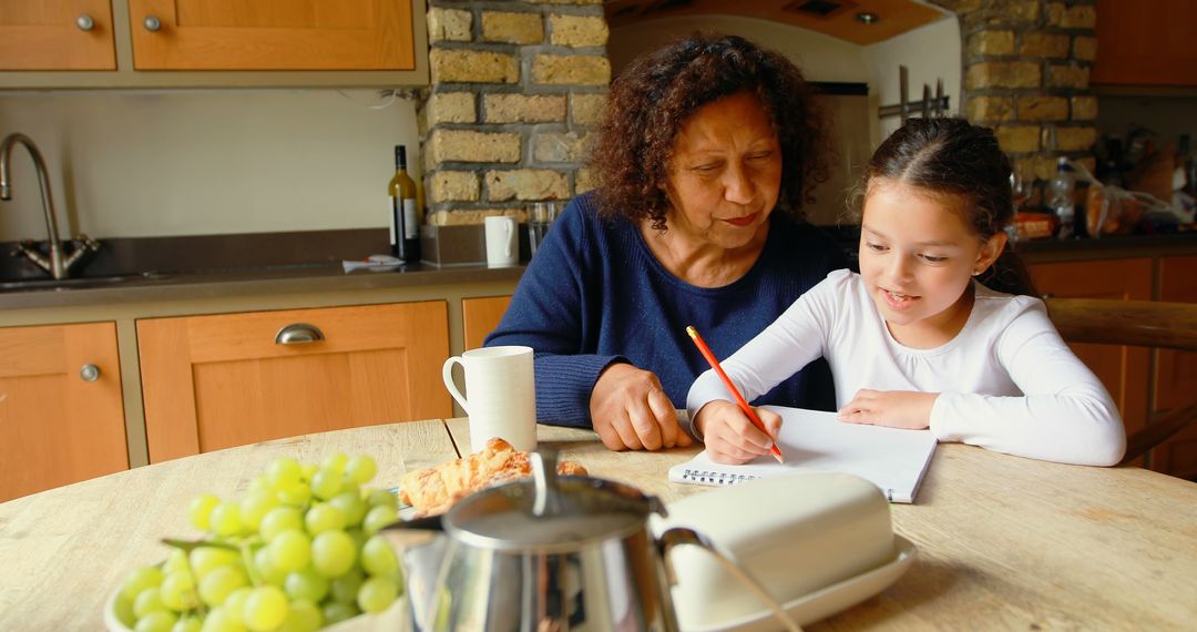 Grandmother Teaching Granddaughter Homework at Kitchen Table - Free Images, Stock Photos and Pictures on Pikwizard.com