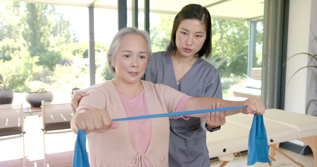 Senior Woman Exercising with Resistance Band Guided by Therapist