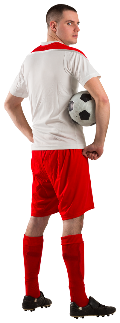 Young football player in red and white uniform holding soccer ball during practice - Download Free Stock Images Pikwizard.com