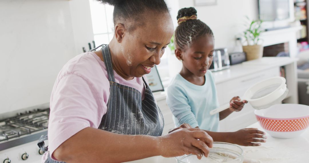 African American grandmother baking with granddaughter in kitchen - Free Images, Stock Photos and Pictures on Pikwizard.com