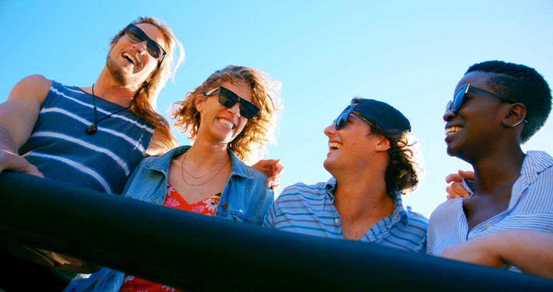 Diverse Group of Friends Laughing Outdoors Under Blue Sky - Free Images, Stock Photos and Pictures on Pikwizard.com