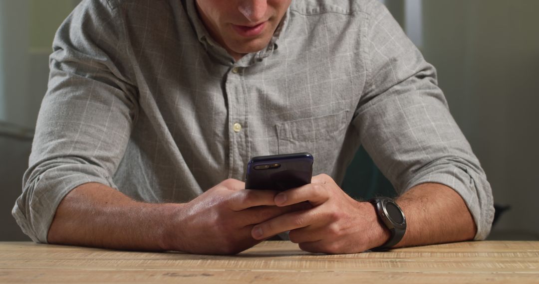 Man Using Smartphone at Wooden Table for Texting - Free Images, Stock Photos and Pictures on Pikwizard.com