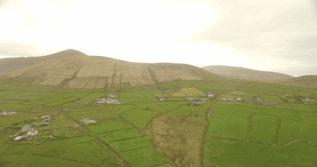Sunset Aerial View of Green Fields and Rolling Hills Offering Pastoral Serenity