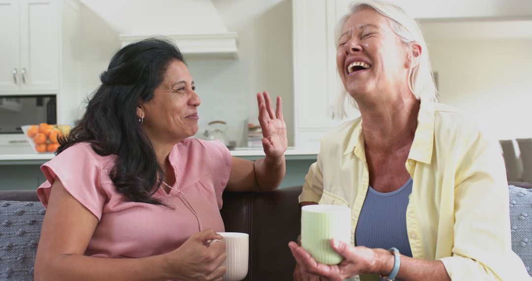 Senior Women Laughing and Drinking Tea in Living Room - Free Images, Stock Photos and Pictures on Pikwizard.com