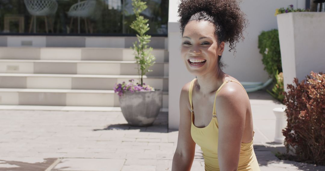 Smiling Woman in Yellow Outfit Sitting Outdoors on a Sunny Day - Free Images, Stock Photos and Pictures on Pikwizard.com