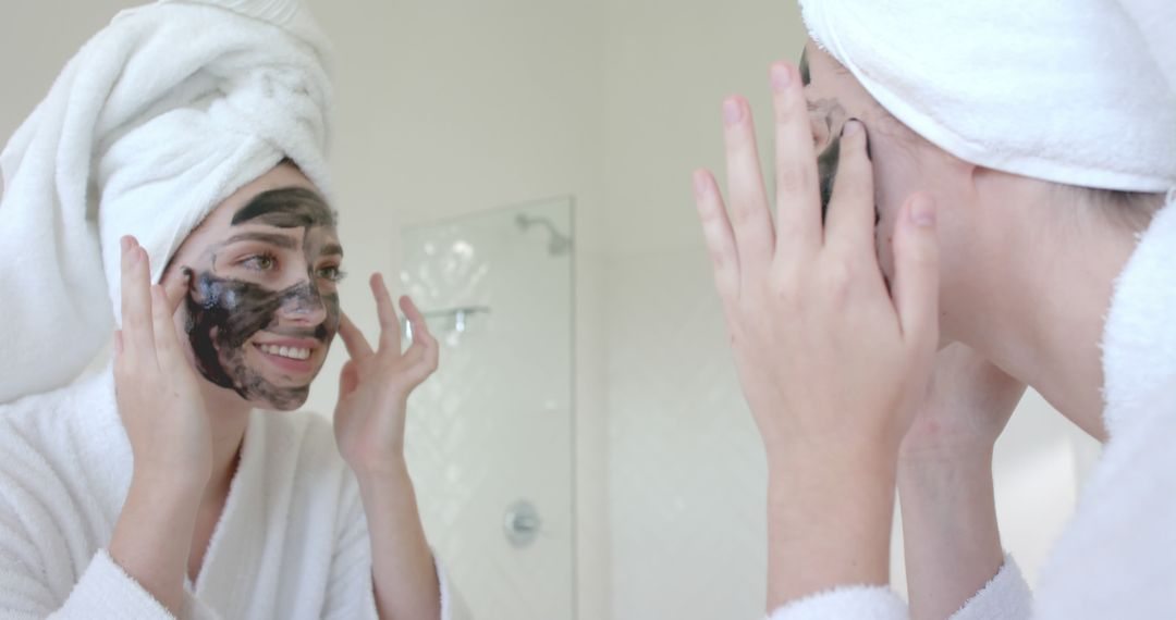 Woman Applying Face Mask While Looking in Bathroom Mirror - Free Images, Stock Photos and Pictures on Pikwizard.com