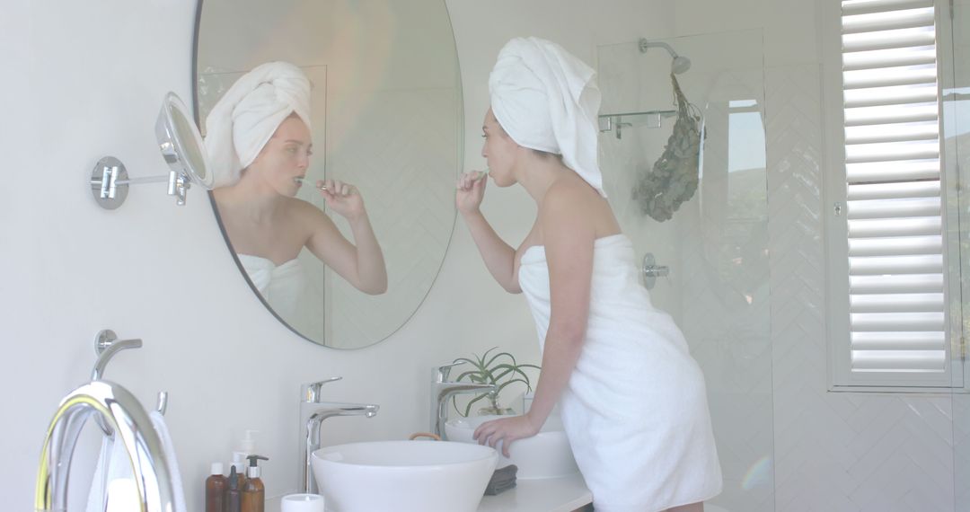 Woman Brushing Teeth in Modern Bathroom with Towel and Mirror - Free Images, Stock Photos and Pictures on Pikwizard.com