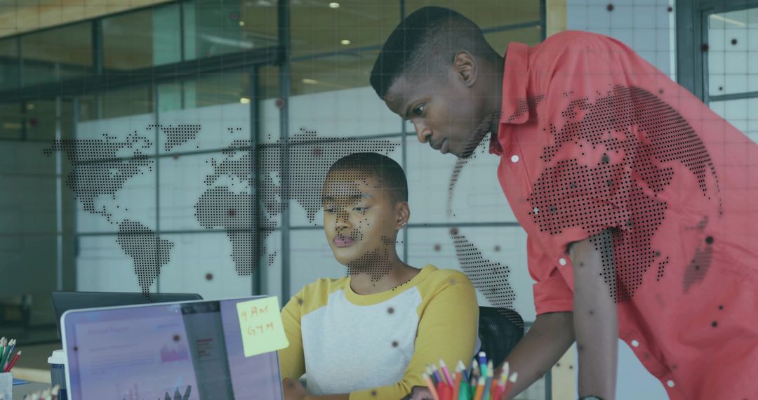 Colleagues Collaborating in Modern Office on Laptop with World Map Overlay