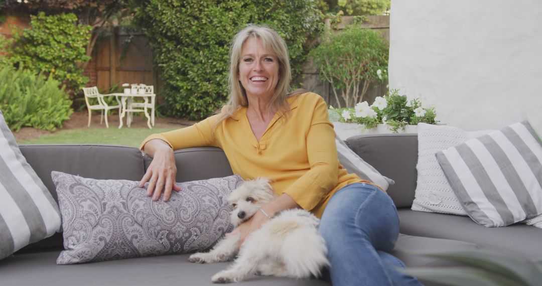 Smiling Woman Relaxing with Dog on Outdoor Couch - Free Images, Stock Photos and Pictures on Pikwizard.com