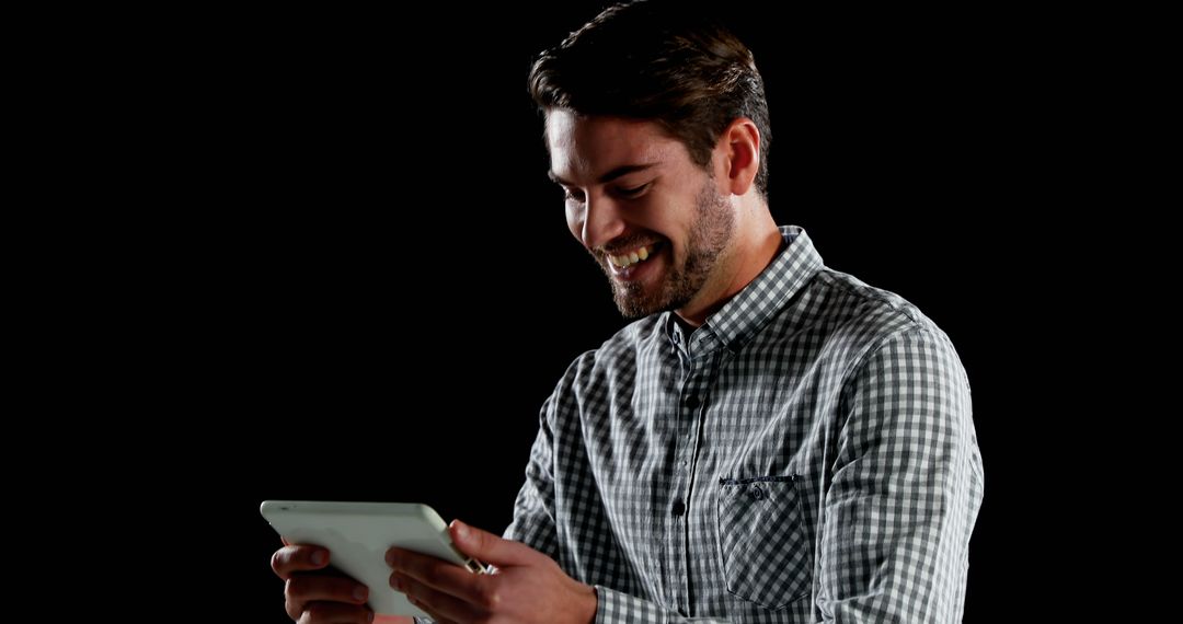 Smiling Man Using Digital Tablet on Black Background - Free Images, Stock Photos and Pictures on Pikwizard.com