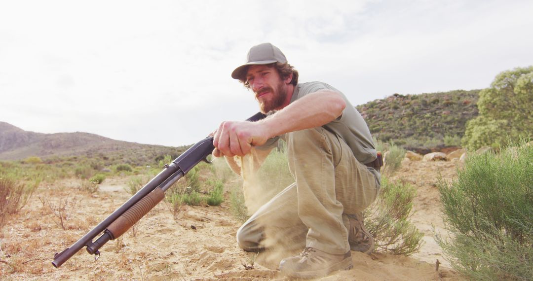 Man Holding Rifle in Desert Landscape - Free Images, Stock Photos and Pictures on Pikwizard.com