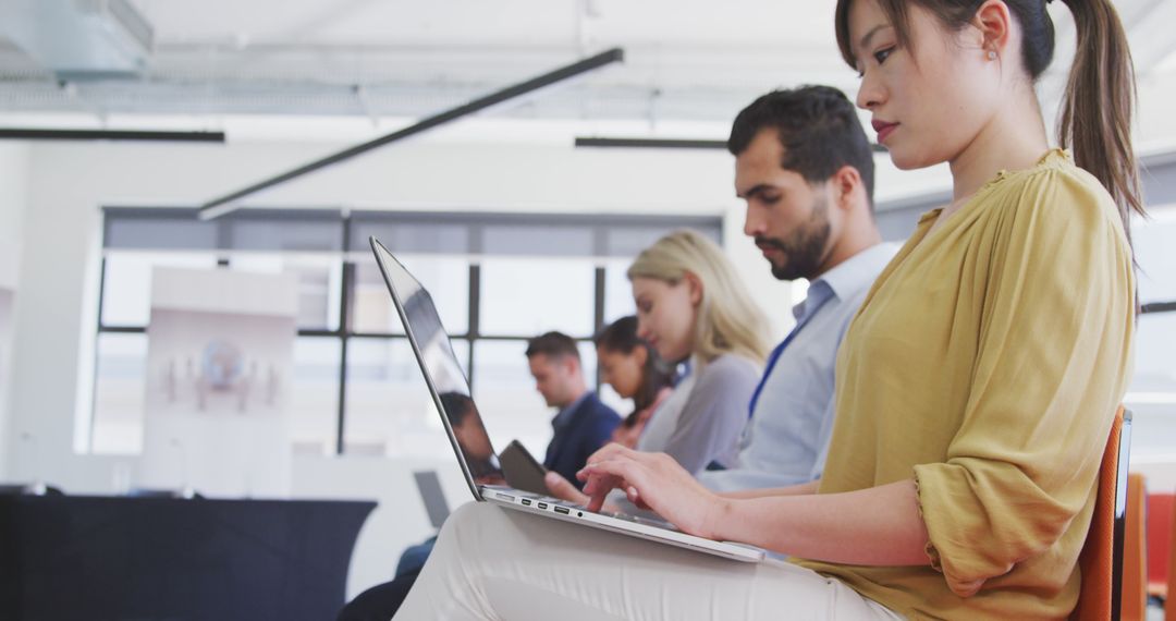 Diverse Professionals Using Laptops in Team Meeting