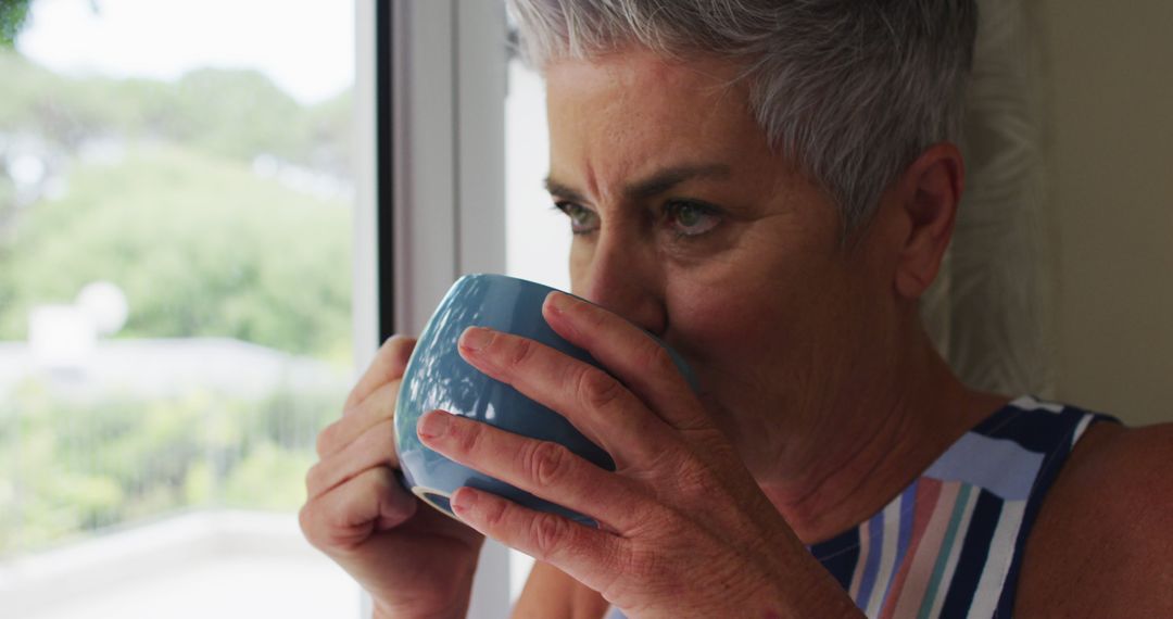 Elderly Woman Enjoying Morning Coffee by the Window - Free Images, Stock Photos and Pictures on Pikwizard.com