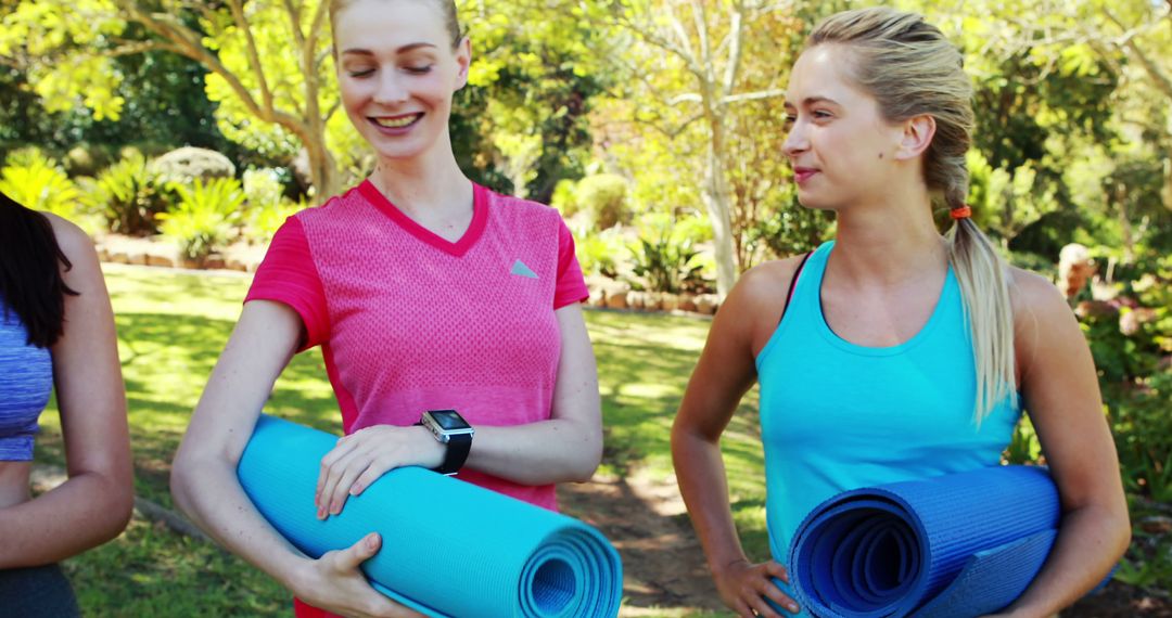 Young Women Holding Yoga Mats in a Sunny Park - Free Images, Stock Photos and Pictures on Pikwizard.com