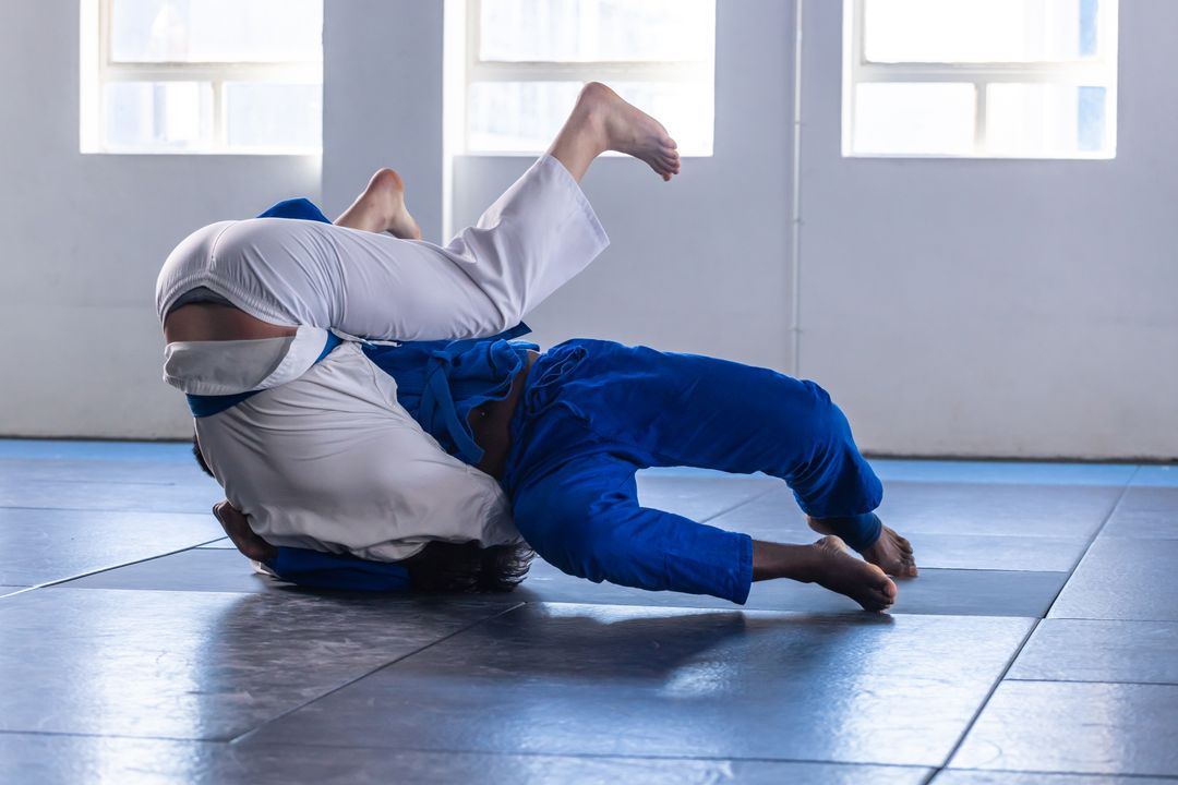 Men Grappling in Jiu-Jitsu Gi on Dojo Mats