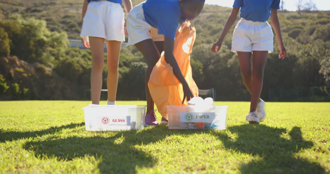 Diverse Children Sorting Recyclables on Sunny Field