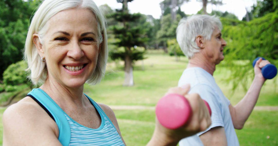 Smiling Senior Woman Lifting Weights Outdoors With Mature Partner - Free Images, Stock Photos and Pictures on Pikwizard.com