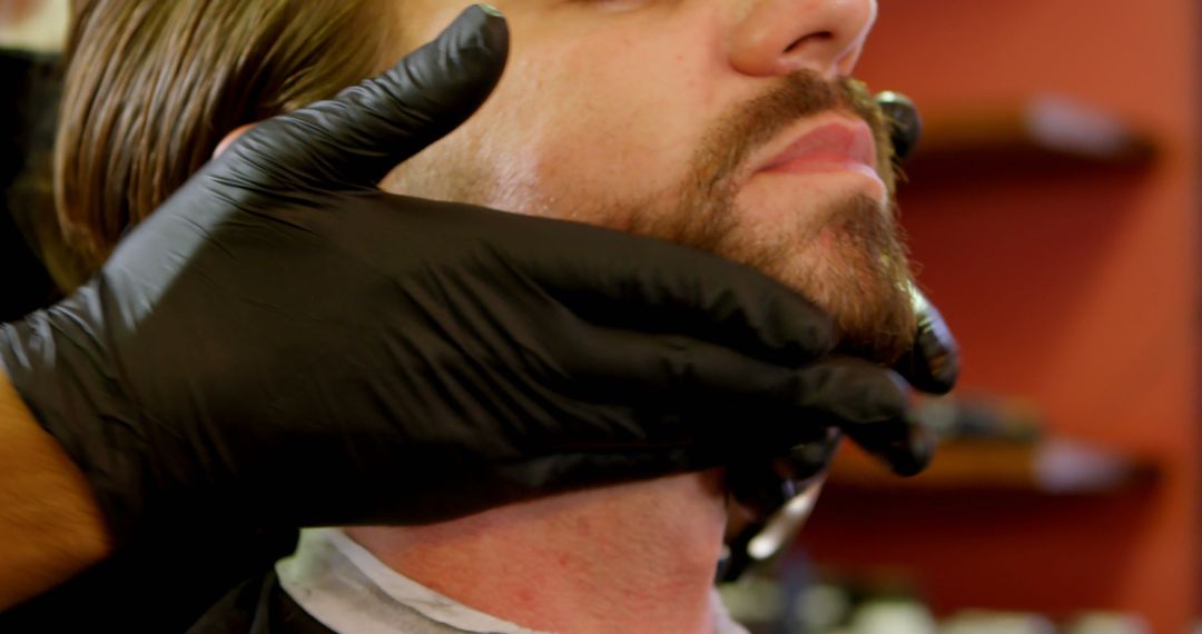 Man shaving beard in barbershop with black gloves - Free Images, Stock Photos and Pictures on Pikwizard.com