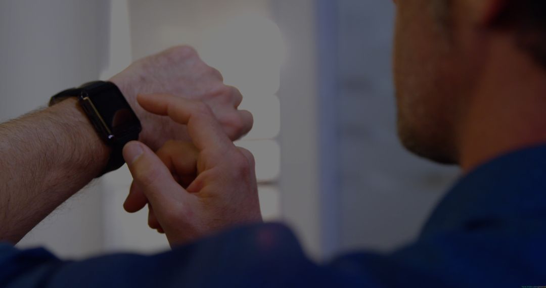 Man Operating Smartwatch While Checking Time Indoors
