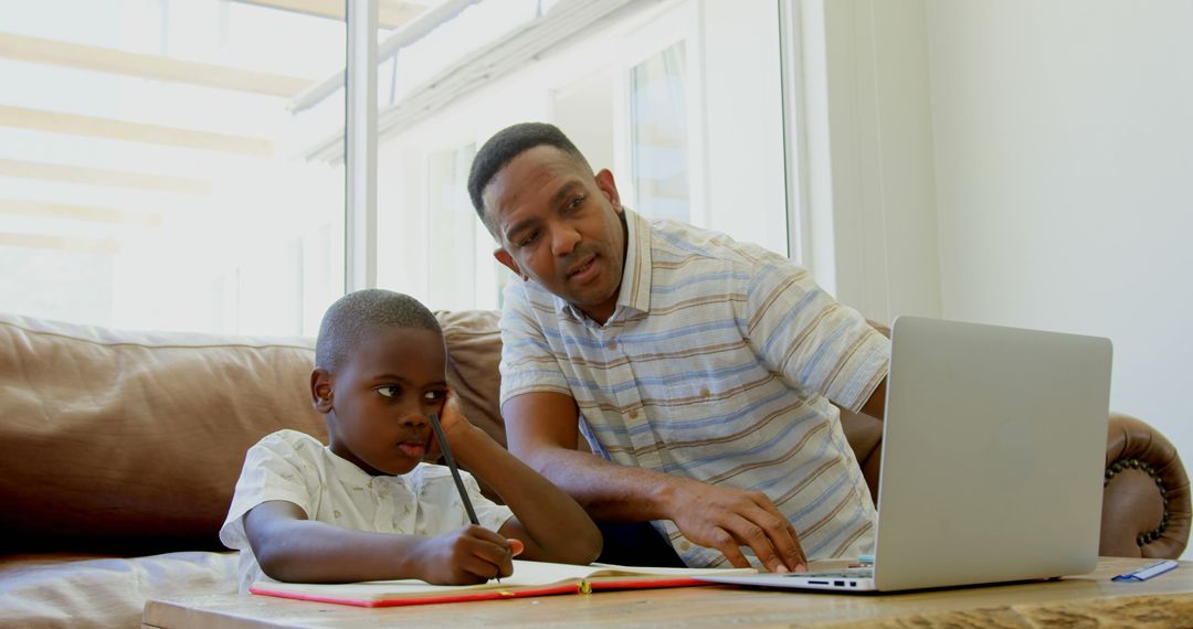 Father Helping Son with Homework on Laptop Indoors - Free Images, Stock Photos and Pictures on Pikwizard.com