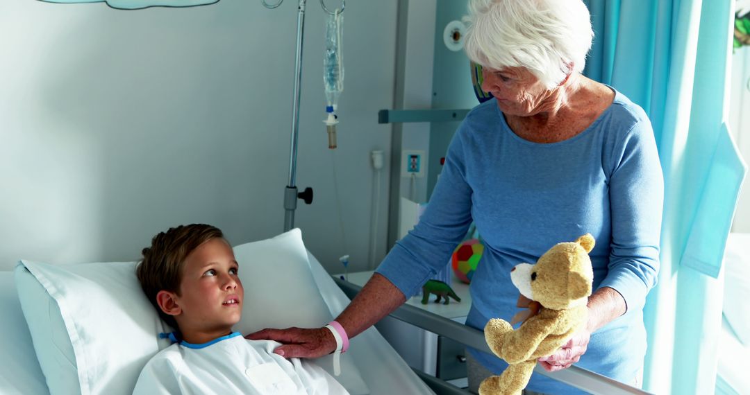 Elderly Woman Comforting Young Boy in Hospital Bed with Teddy Bear - Free Images, Stock Photos and Pictures on Pikwizard.com