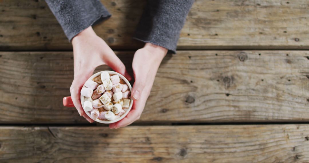 Hands Holding Hot Chocolate with Marshmallows on Rustic Wooden Table - Free Images, Stock Photos and Pictures on Pikwizard.com