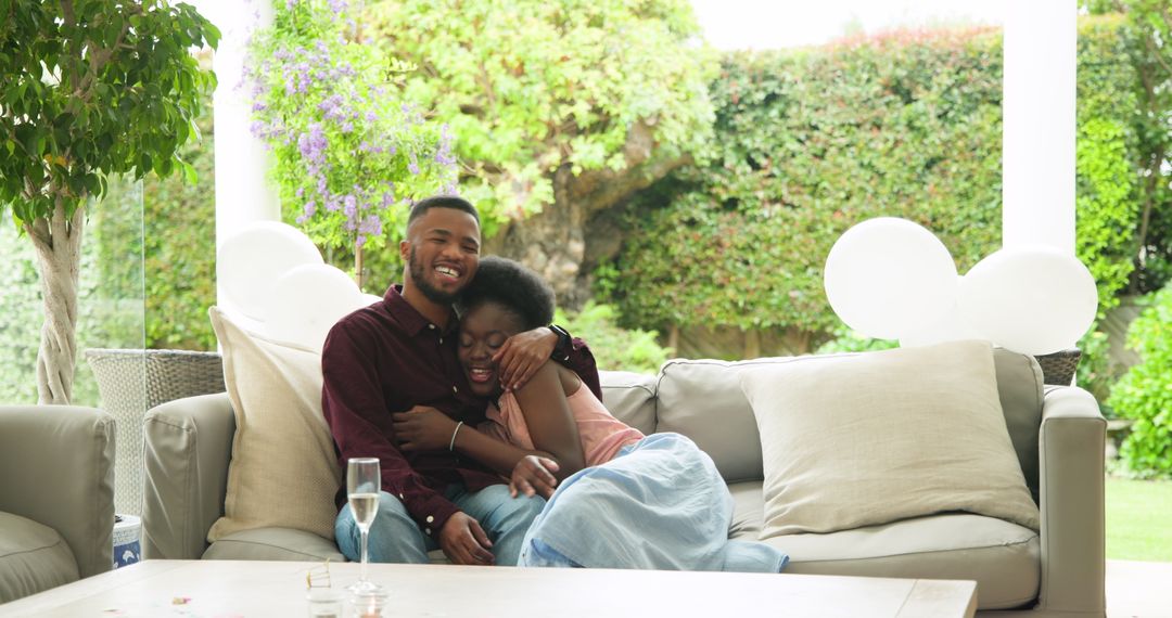 Happy Couple Embracing on Patio Sofa in Garden