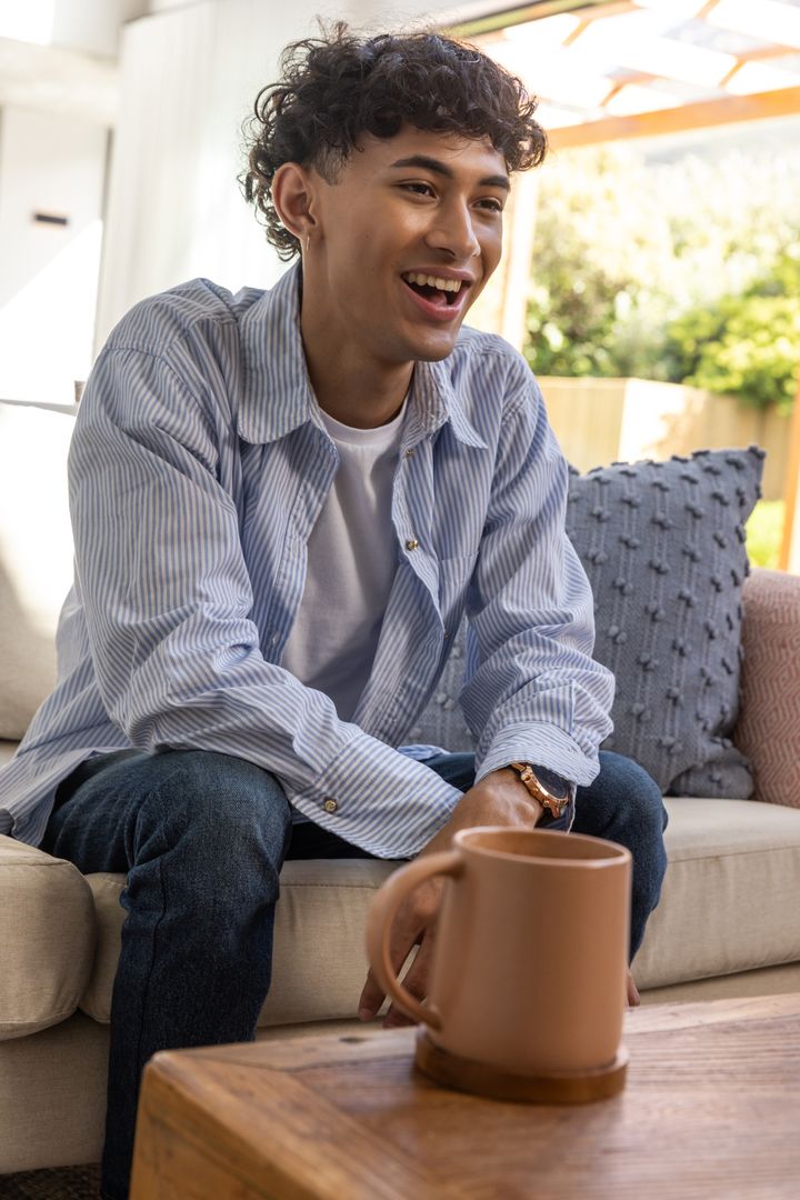 Young Man Enjoying Relaxing Moment at Home with Coffee Mug