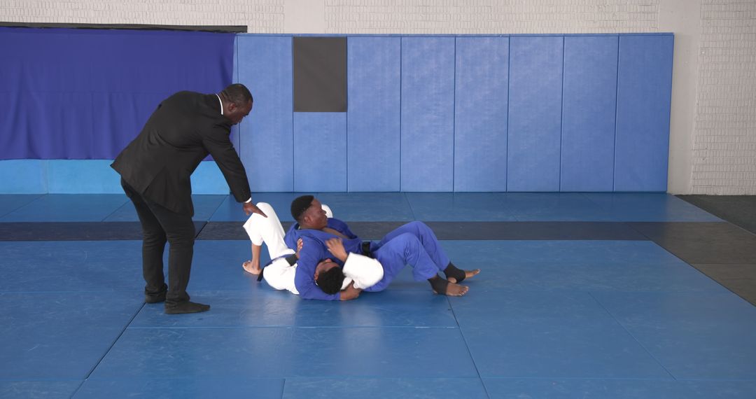 Martial Arts Instructor Supervising Students in Grappling Practice