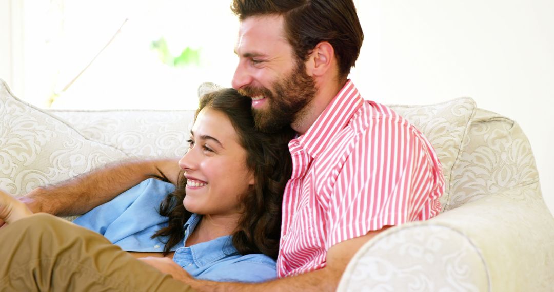 Happy Couple Relaxing on Couch Smiling and Laughing - Free Images, Stock Photos and Pictures on Pikwizard.com