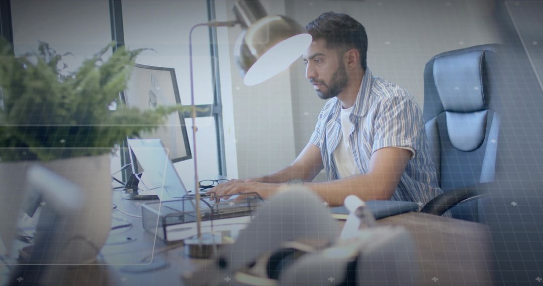 Focused Professional Man Typing at Modern Office with Greenery