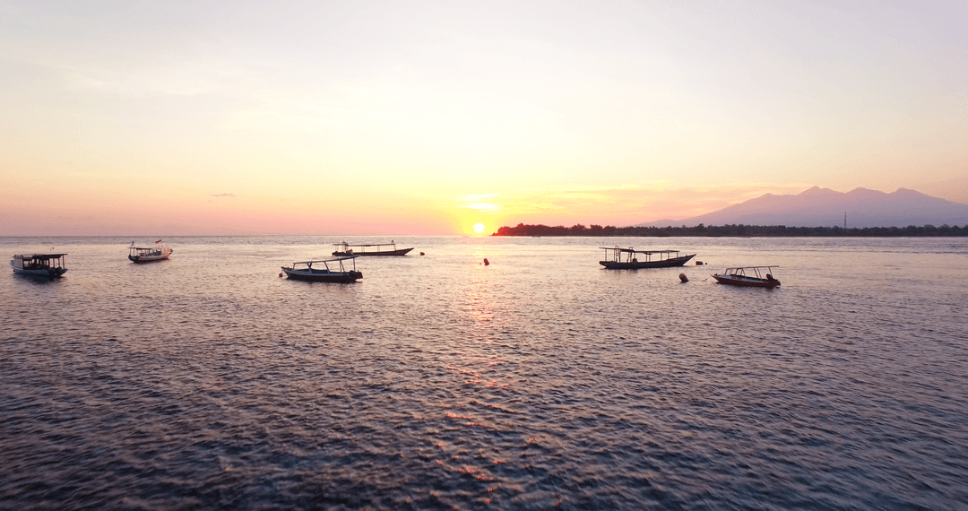 Tranquil Sea at Sunset with Floating Boats Transparent Beauty