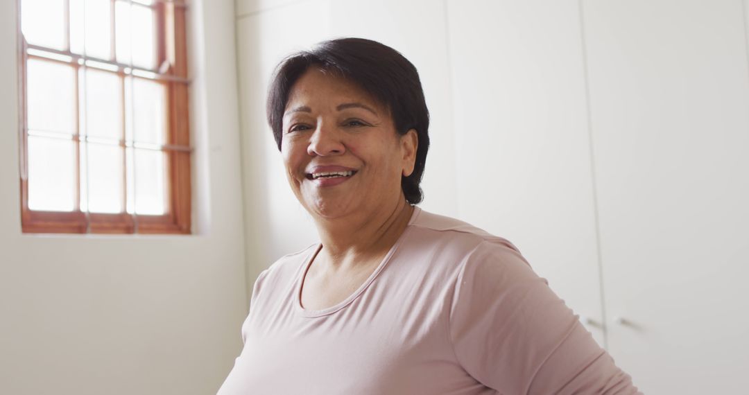 Portrait of african american senior woman smiling near the window at home - Free Images, Stock Photos and Pictures on Pikwizard.com