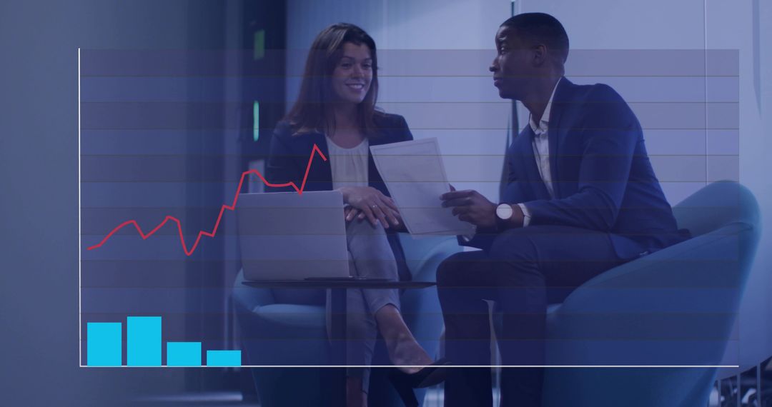 Executives reviewing financial chart with laptop and documents in modern office lounge