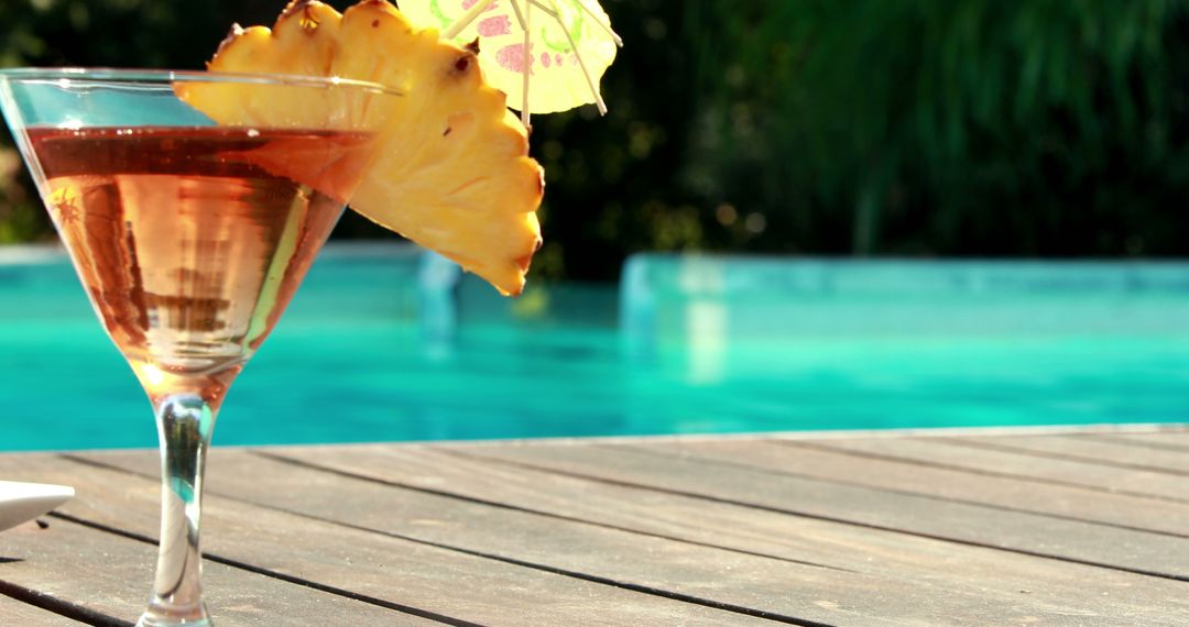 Close-up of Tropical Cocktail by Poolside with Pineapple Slice and Umbrella - Free Images, Stock Photos and Pictures on Pikwizard.com