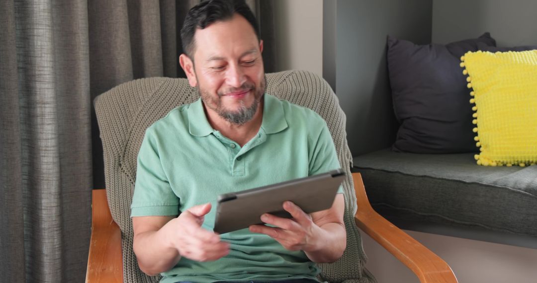 Happy Asian Man Using Tablet Relaxing at Home